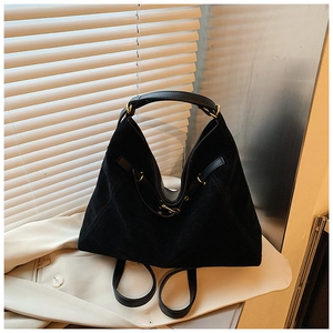 Detail of matte black multi-way tote bag with gold hardware and smooth leather straps