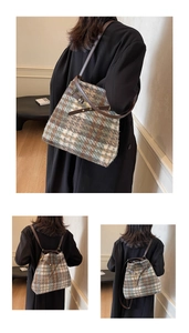 Detail von kariertem Tweed-Material und Lederriemen mit goldenen Metallschnallen