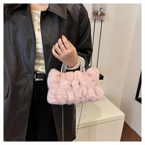 Vue détaillée d'un sac à main en peluche rose avec poignées en anneaux de strass