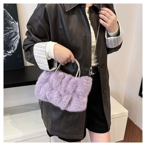 Détail d'un sac à main en peluche lilas avec texture tressée et poignée ornée de strass