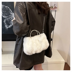 Détail de la texture en fausse fourrure blanche et poignées en métal ornées de strass