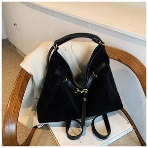 Detail of black large capacity hobo bag with gold hardware and suede texture