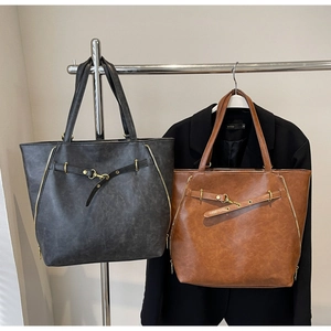 Detail showing vintage textured leather tote bags in dark grey and brown colors