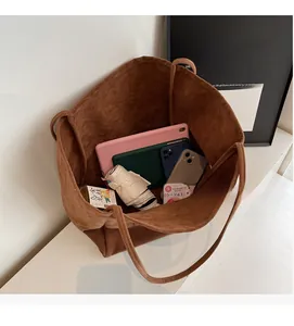 Spacious interior of dark brown suede tote bag holding a tablet, phone and umbrella