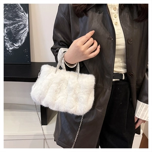 Détail du sac à main en fausse fourrure blanche avec textures et poignée en perles chic