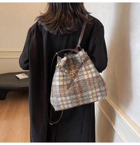 Detailaufnahme einer Wollkaro-Beuteltasche mit braunen Lederriemen als Rucksack getragen