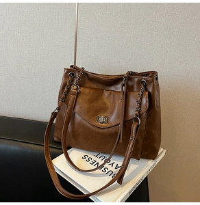 Dettaglio della borsa tote marrone scuro con chiusura a rotazione argento e catena