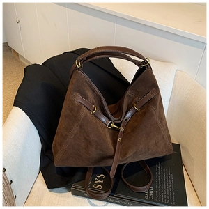 Macro detail of high-quality brown suede tote bag with leather straps and gold hardware