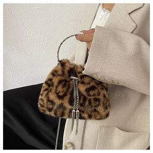 Detail der flauschigen Tasche mit Leopardenmuster, silbernem Ringgriff und Kettenzugband