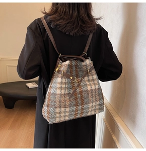 Detail der blau-braunen Tweed-Textur an einem Retro-Rucksack mit Lederriemen