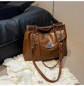 Dettaglio della borsa tote marrone scuro con trama in pelle e chiusura a girello