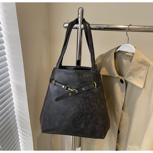 Detail of vintage tote bag with decorative buckle belt and charcoal leather texture