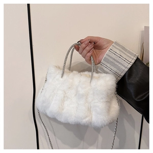 Vue détaillée du sac en peluche blanche avec poignées serties de cristaux et chaîne argent