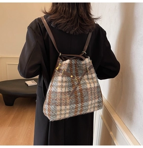 Detailansicht der karierten Woll-Tasche mit Lederriemen und goldenen Metallteilen