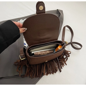 Detail view of the brown fringe saddle bag showing spacious interior with zipper closure