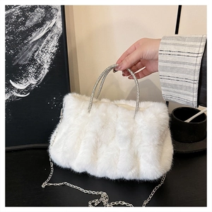 Détail du sac à main en fausse fourrure blanche avec anses en strass et chaîne en argent