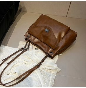 Dettaglio borsa tote vintage marrone con chiusura in metallo e tracolla a catena