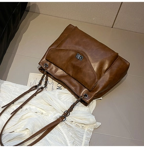 Vista dettagliata della borsa tote marrone scuro con trama opaca e tracolla a catena