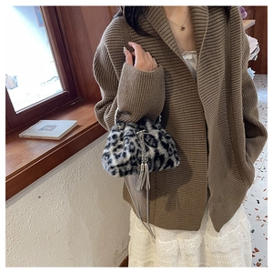 Detail einer Handtasche aus Kunstpelz mit Leopardenmuster und silberner Kettenquaste im Winter