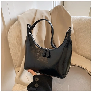 Dettaglio borsa hobo in ecopelle nera lucida con cerniera argentata e manico curvo elegante