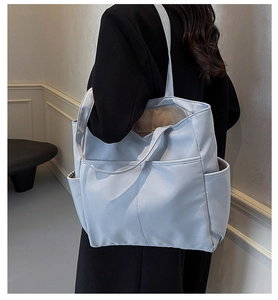 Détail du sac cabas bleu clair montrant les poches latérales et la grande capacité quotidienne