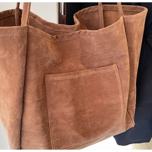 Detail of vintage brown suede tote bag featuring fine stitching and front patch pocket