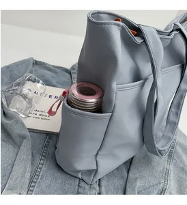 Détail du sac cabas bleu clair avec poche latérale pour bouteille d'eau sur denim