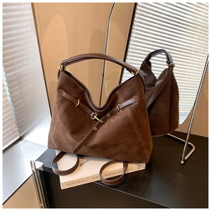 Close-up of brown suede tote bag with golden metal buckle on professional leather straps