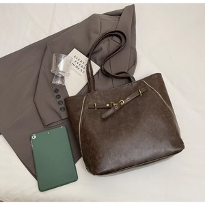 Flat lay of retro coffee brown tote bag with side zippers and tablet in business scene