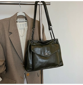 Dettaglio della borsa tote verde oliva con chiusura girevole in metallo e tracolla a catena