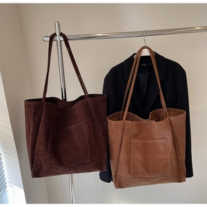 Detail view of large faux suede tote bags in coffee and caramel with functional front pockets