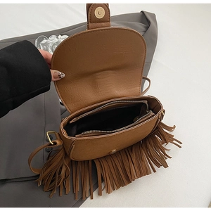 Detail view of the brown tassel saddle bag showing interior lining and zipper pocket
