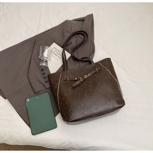 Detail of vintage dark brown tote bag with metallic zippers and textured faux leather finish