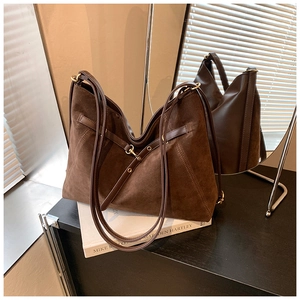 Detailed view of large dark brown suede tote bag with metal buckle and shoulder straps