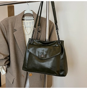 Dettaglio borsa tote verde oliva con chiusura a scatto vintage e tracolla a catena