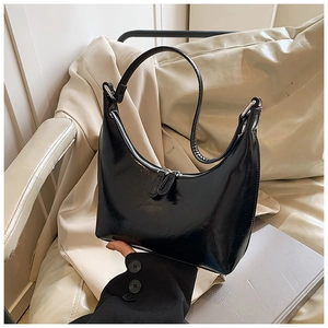 Dettaglio borsa a mezzaluna nera in pelle con texture liscia e cerniere in metallo argento