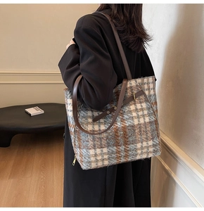 Details der karierten Wollmischung-Tote-Bag mit braunen Lederriemen und Metallelementen