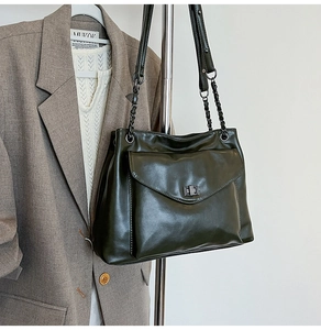 Dettaglio borsa tote verde oliva con chiusura a scatto argento e tracolla a catena