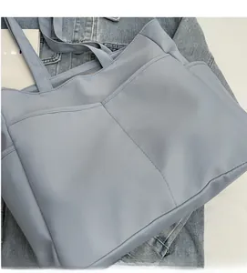 Gros plan d'un sac cabas en toile bleu clair avec plusieurs poches et texture mate douce