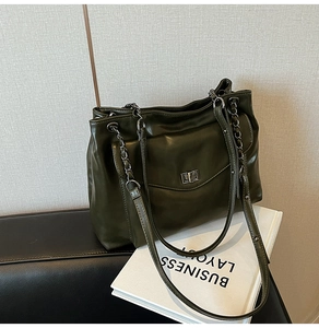 Dettaglio della borsa tote in pelle verde oliva con chiusura a scatto e tracolla a catena