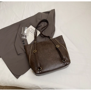 Macro view of vintage dark brown tote bag with textured faux leather and gold zipper detail