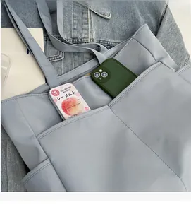 Vue détaillée de la poche extérieure du sac cabas bleu clair et texture du nylon durable