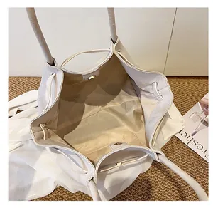 Vista dall'alto dell'interno spazioso della borsa tote crema con chiusura magnetica