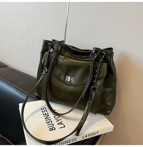 Dettaglio della borsa tote verde oliva con chiusura a scatto argentata e tracolla a catena