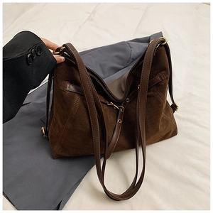 Detail view of large vintage brown suede tote bag with leather straps and gold buckles
