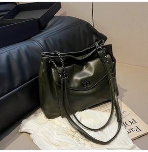 Dettaglio della borsa tote in pelle verde oliva con spalline a catena e tasca con chiusura