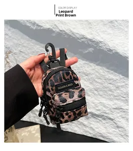 Detail of mini leopard print crossbody bag with black zipper and a functional hook