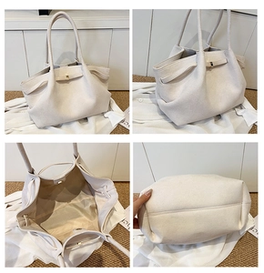 Vista dettagliata della borsa tote in pelle scamosciata bianco crema con manici sottili e fibbia