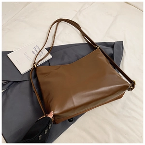 Detailed view of brown PU leather hobo bag with vintage copper metal hardware accents