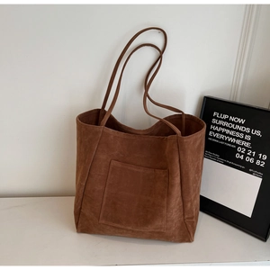 Detailed view of dark brown suede tote bag with front pocket and slim shoulder straps